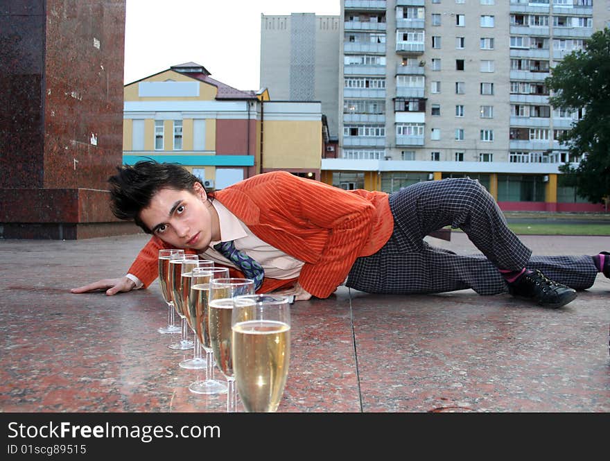 Young man with champagne rests on the pedestal