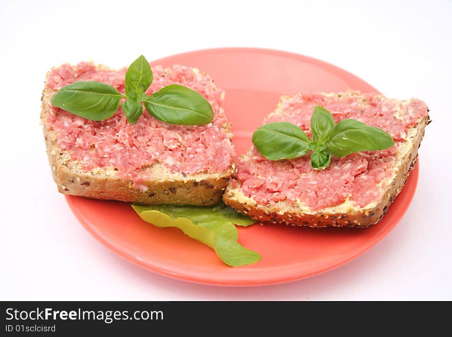 A breakfast of bread with sausage and basil