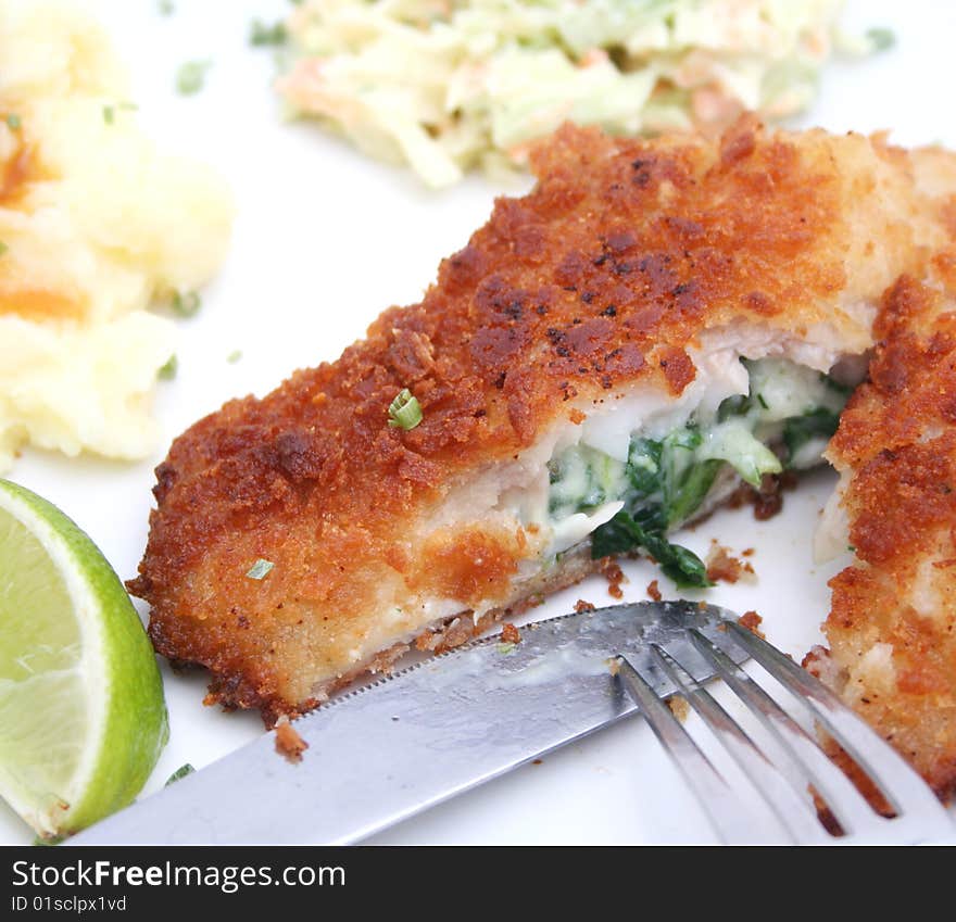 A meal of fish filled with spinach, potatoes and cabbage-salad. A meal of fish filled with spinach, potatoes and cabbage-salad