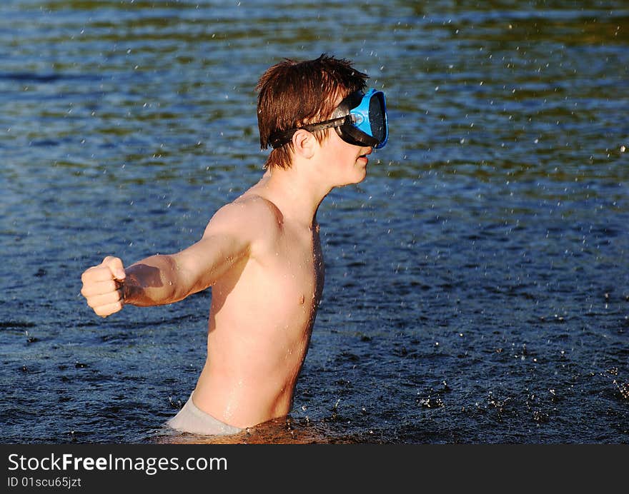 The boy with a mask playing water games in a lake. The boy with a mask playing water games in a lake.