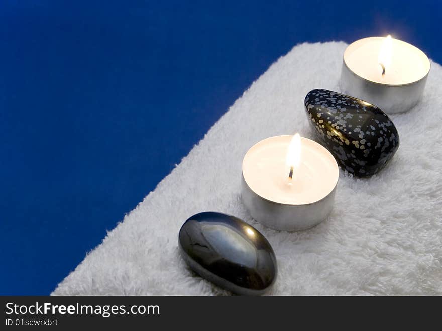 Candles and massage stones on a towel. Candles and massage stones on a towel