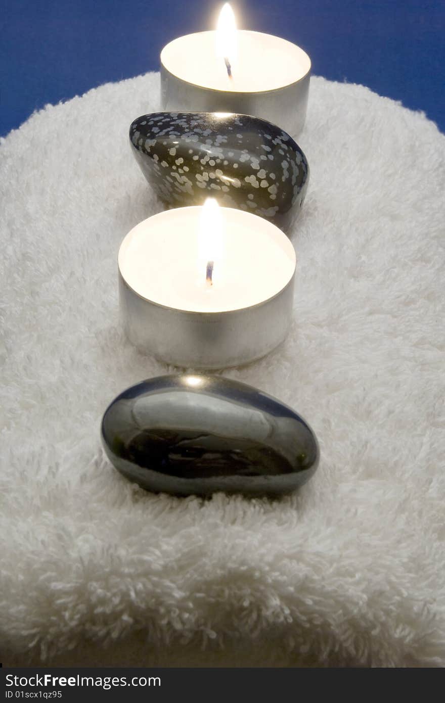 Candles and massage stones on a towel. Candles and massage stones on a towel