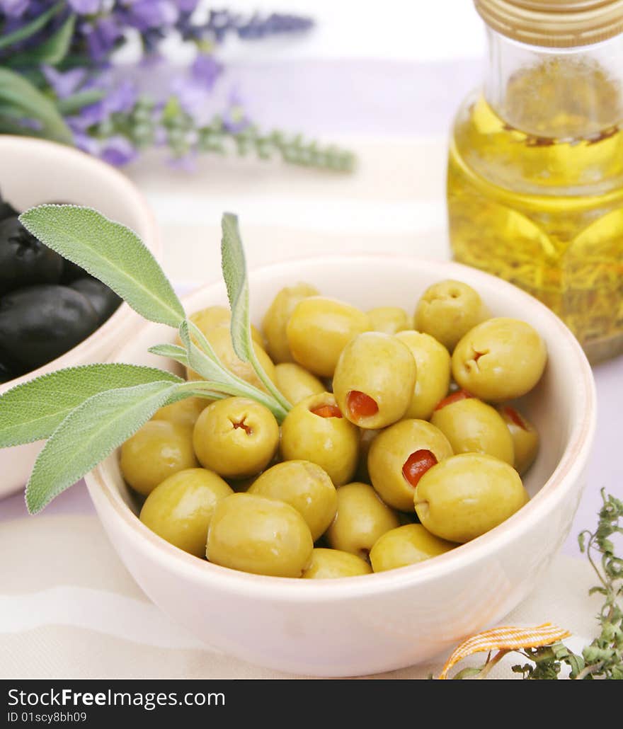 Some green olives in a bowl with sage