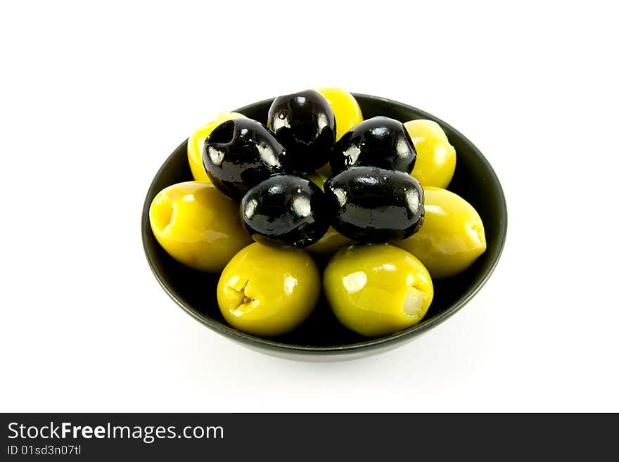 Green and black olives in a small black bowl on a white background. Green and black olives in a small black bowl on a white background