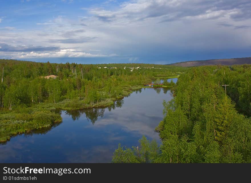 Clouds are reflected in silent northern small river among green hills. Clouds are reflected in silent northern small river among green hills