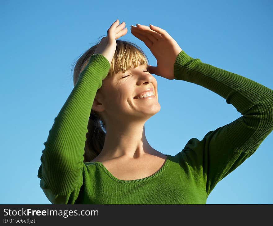 Portrait of the young woman posing on a background of the dark blue sky. Portrait of the young woman posing on a background of the dark blue sky