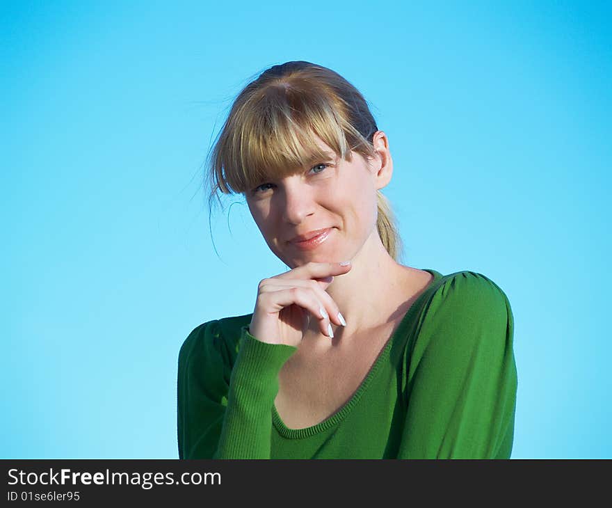 Portrait of the young woman posing on a background of the dark blue sky. Portrait of the young woman posing on a background of the dark blue sky