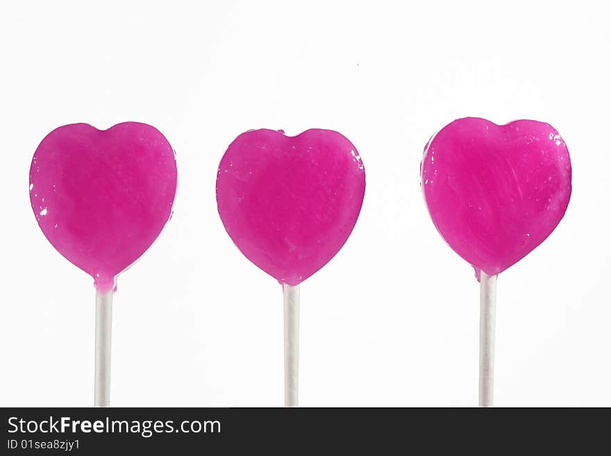 Three pink heart lollipops isolated