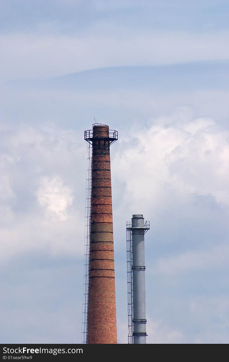 Big industrial chimneys polluting our environment, with blue sky in background