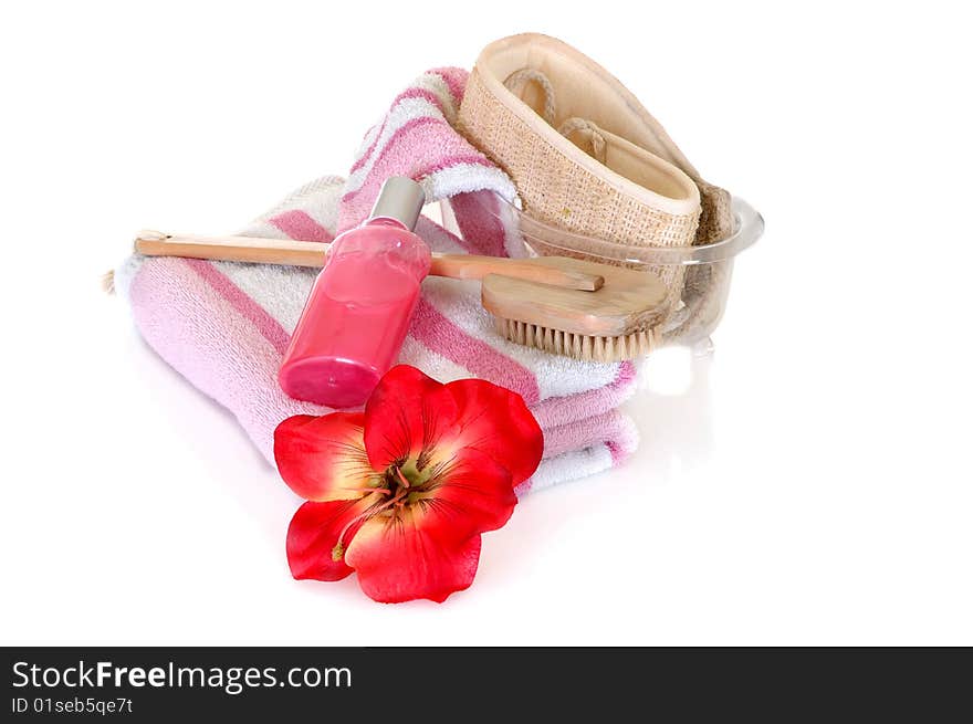 Spa essentials surrounded by rose petals on white background, reflective surface. Spa essentials surrounded by rose petals on white background, reflective surface