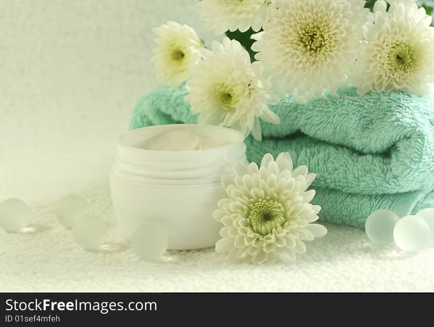 Bowl of cream, towel and flowers. Spa composition.