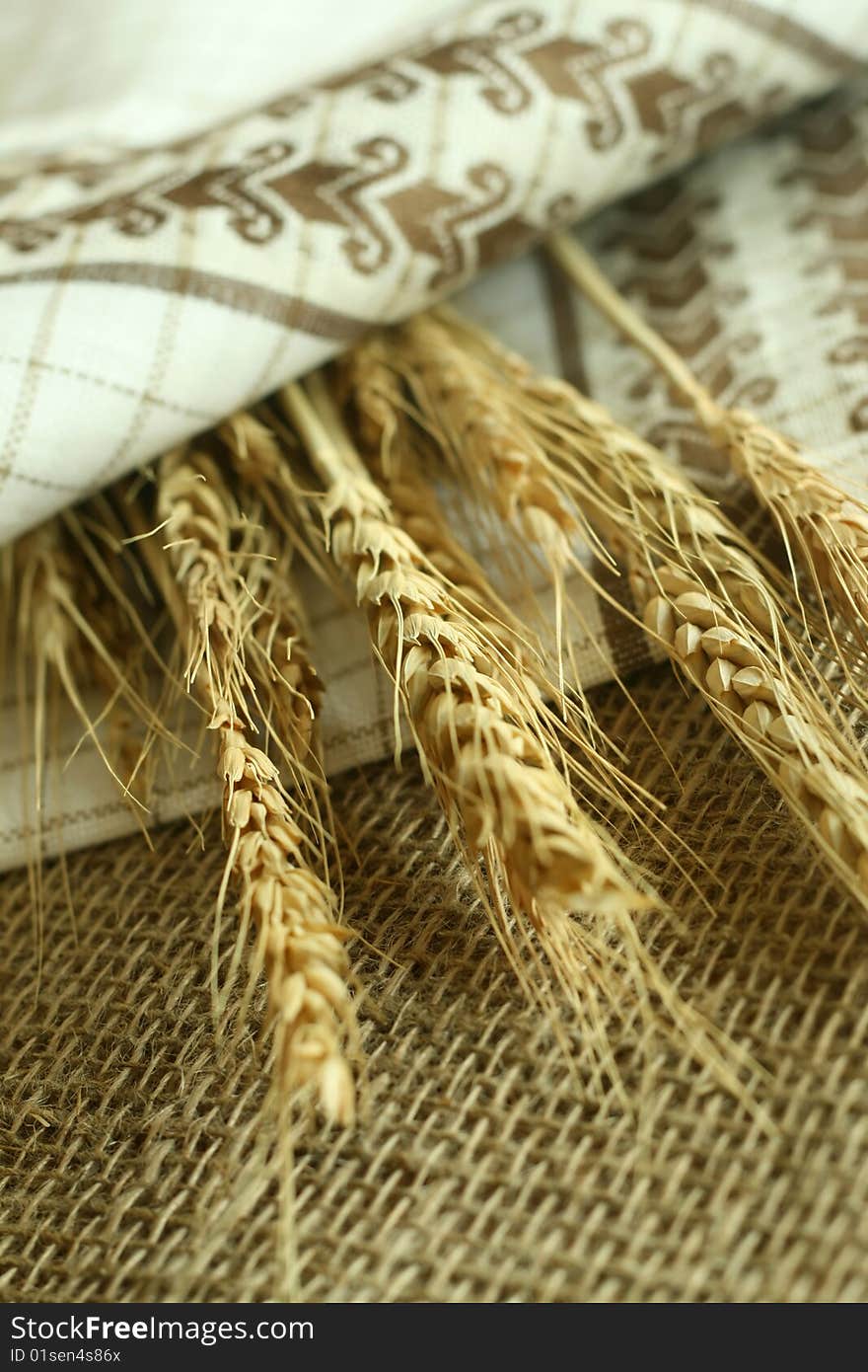 wheat ears and towel with ornament on sacking. wheat ears and towel with ornament on sacking