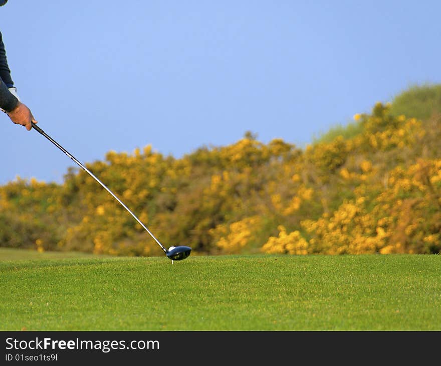 A senior player hit the golf ball with a wood club. A senior player hit the golf ball with a wood club