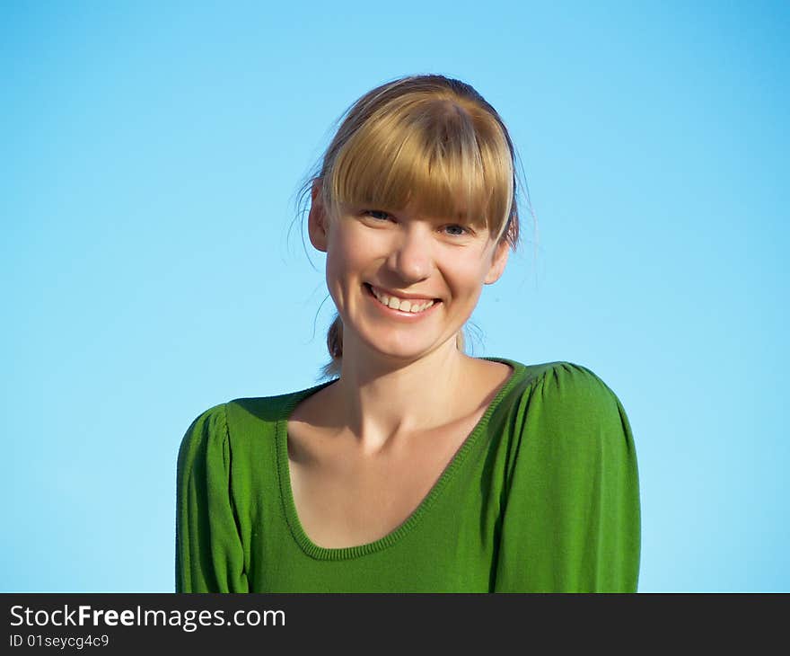 Portrait of the young woman posing on a background of the dark blue sky. Portrait of the young woman posing on a background of the dark blue sky