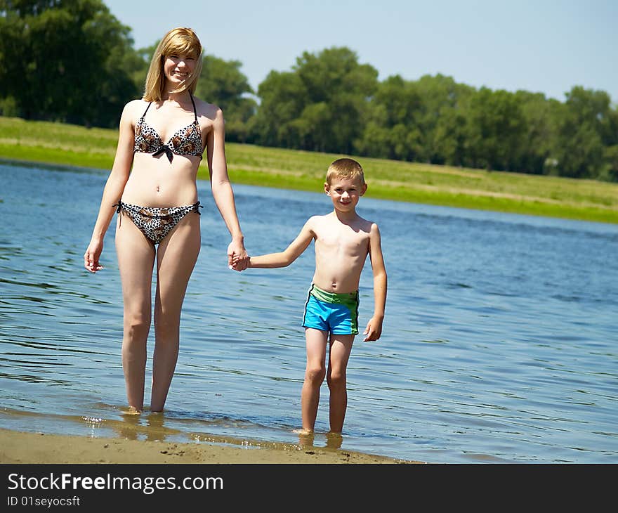 Young mum plays with the son on the nature. Young mum plays with the son on the nature