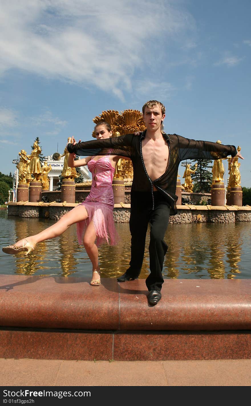 Couple dancing outdoor in front of a fountain