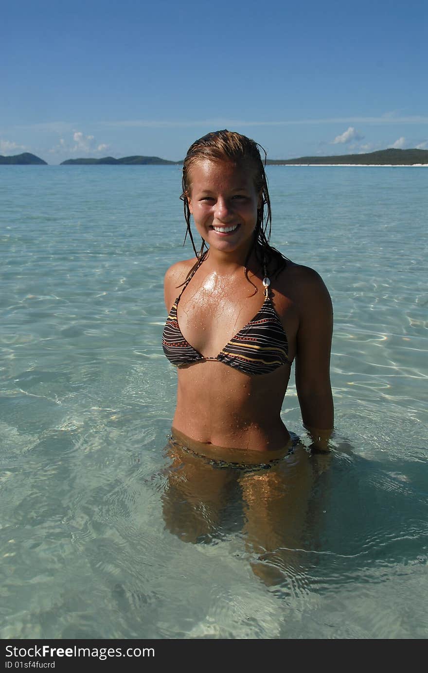 Beautiful young teenage girl standing in water