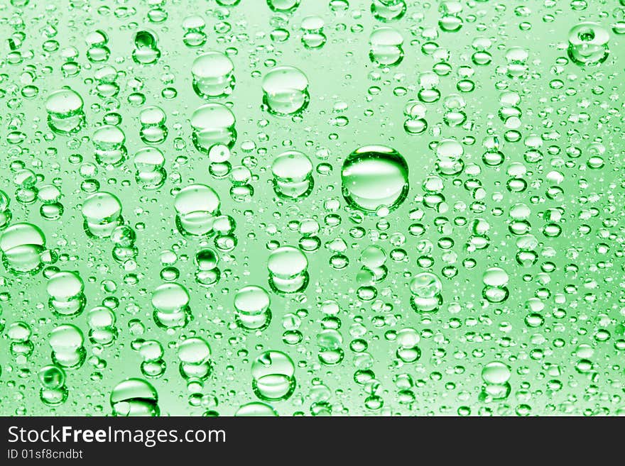 Green water drops against mirror