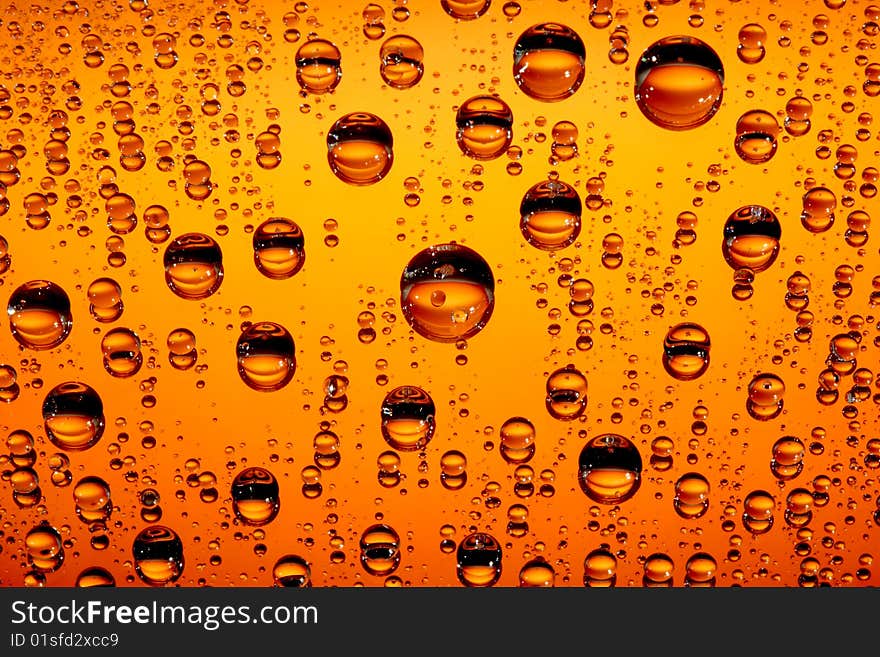 Orange water drops against black background