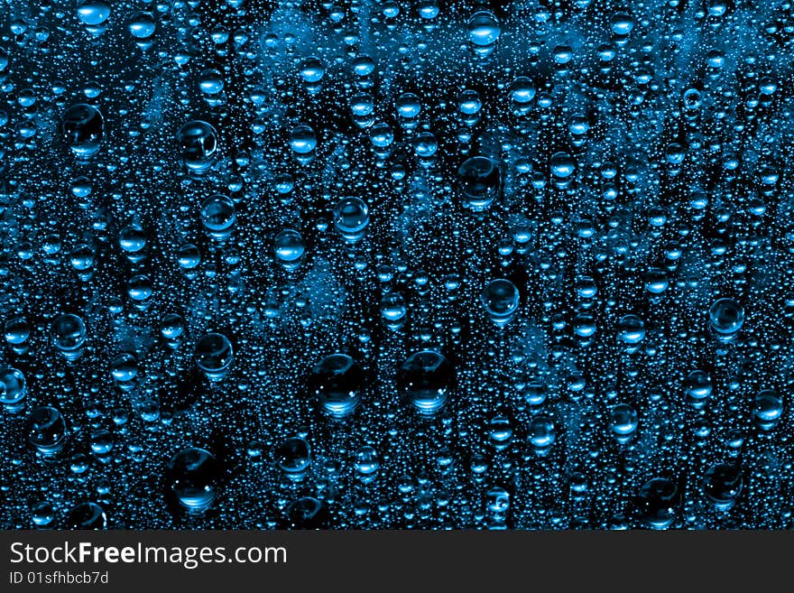 Blue water drops against black background