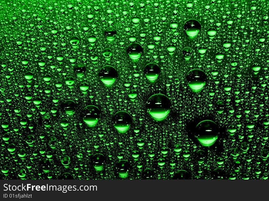 Green water drops against black background