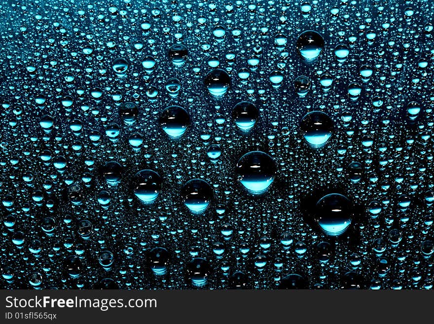 Macro of blue water drops against mirror