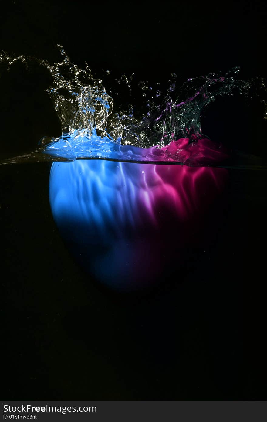 Blue and pink heart splashing underwater against black background. Blue and pink heart splashing underwater against black background