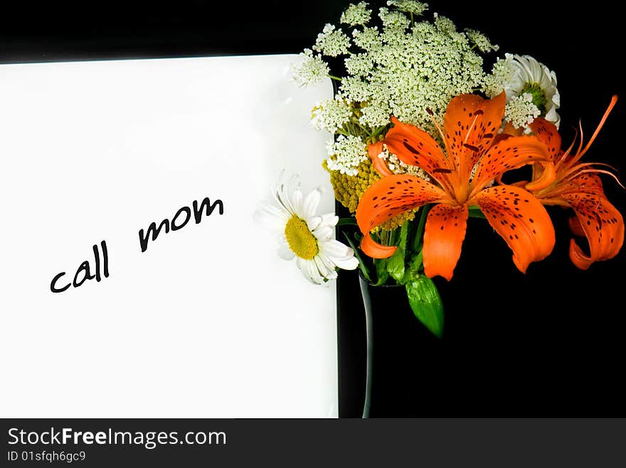 A message on dry erase board with bouquet in black vase. A message on dry erase board with bouquet in black vase.