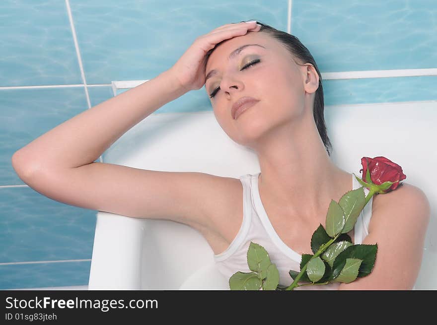 Gorgeous brunette with flower. In a bathroom