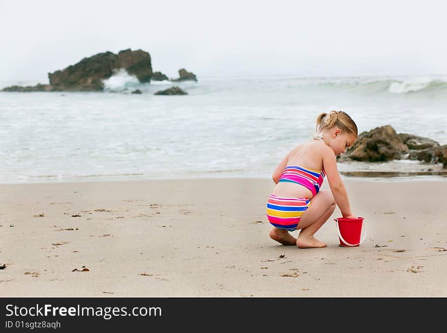 Four year old playing playing in the sand at the beach. Four year old playing playing in the sand at the beach.