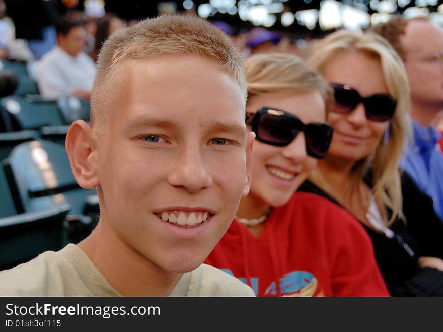 Family sit together and watch baseball game. Family sit together and watch baseball game