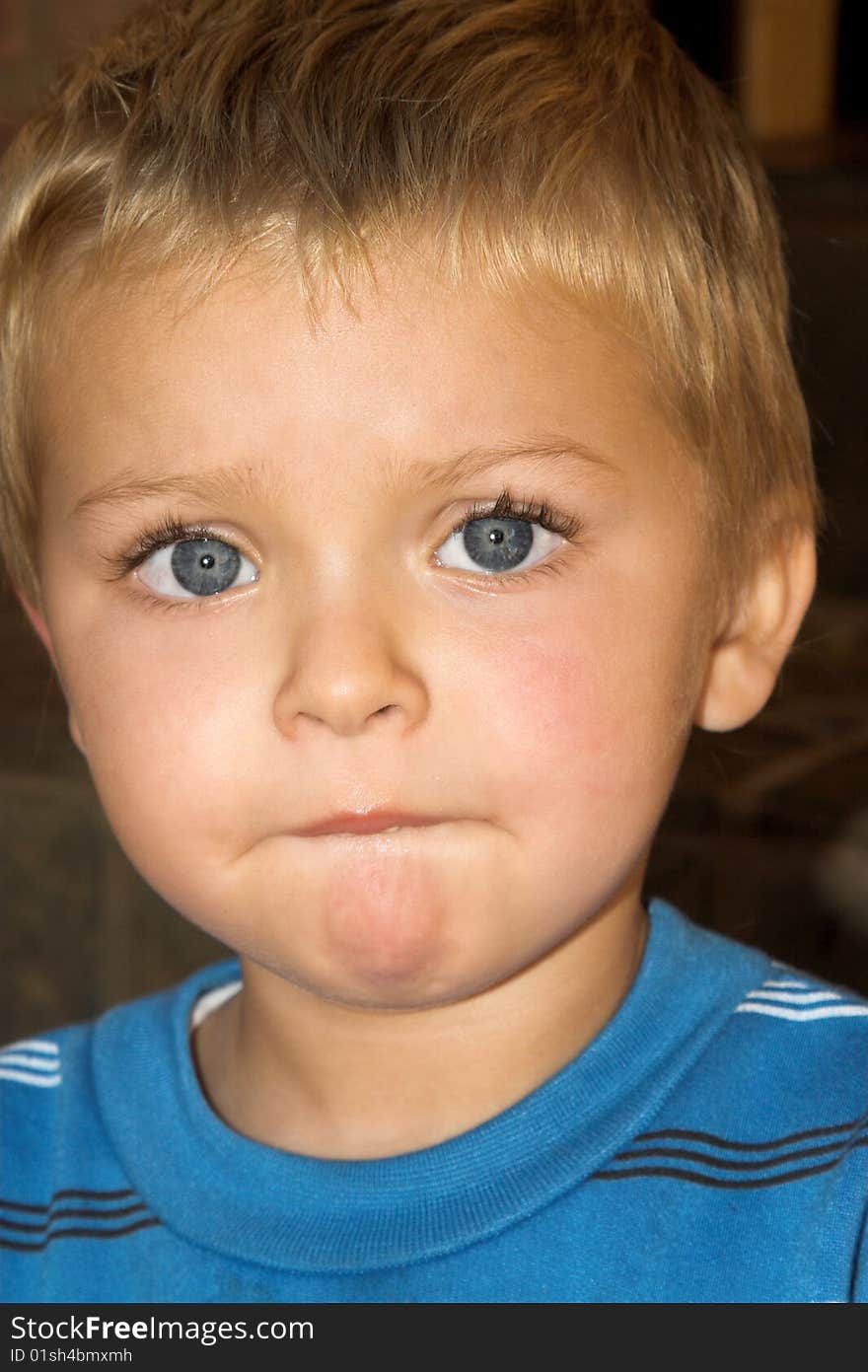 Young boy with beautiful blue eyes, serious expression