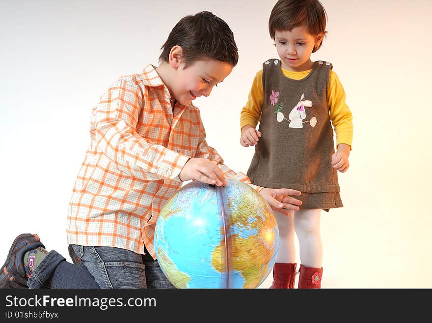 Boy and girl playing with globe in office. Boy and girl playing with globe in office