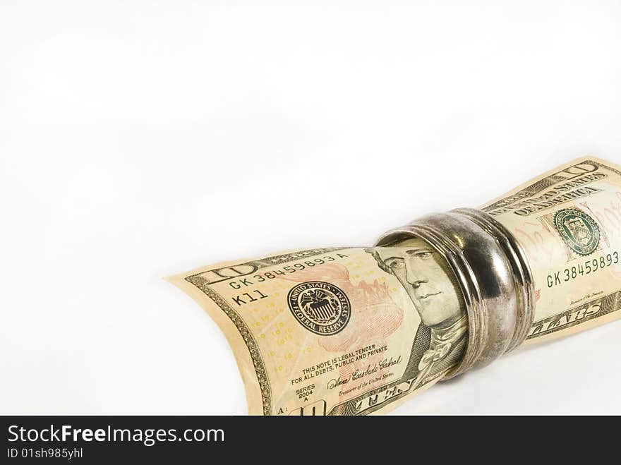 A rolled up ten US dollar bill in a silver napkin ring