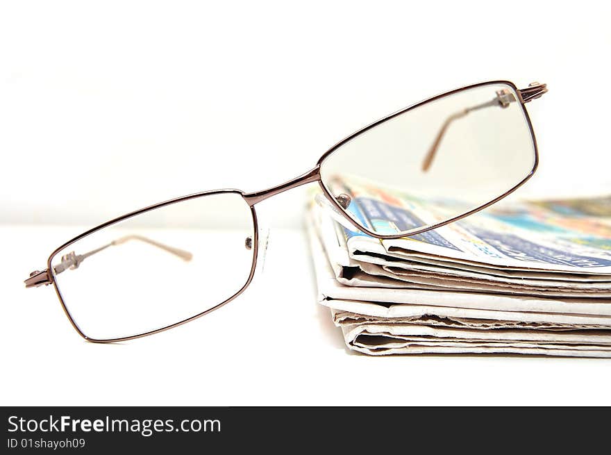 Few fresh newspaper with the pair of glass on  table