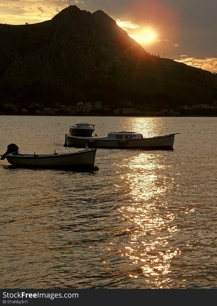 Reflexion Of Light In The Sunset With Boats