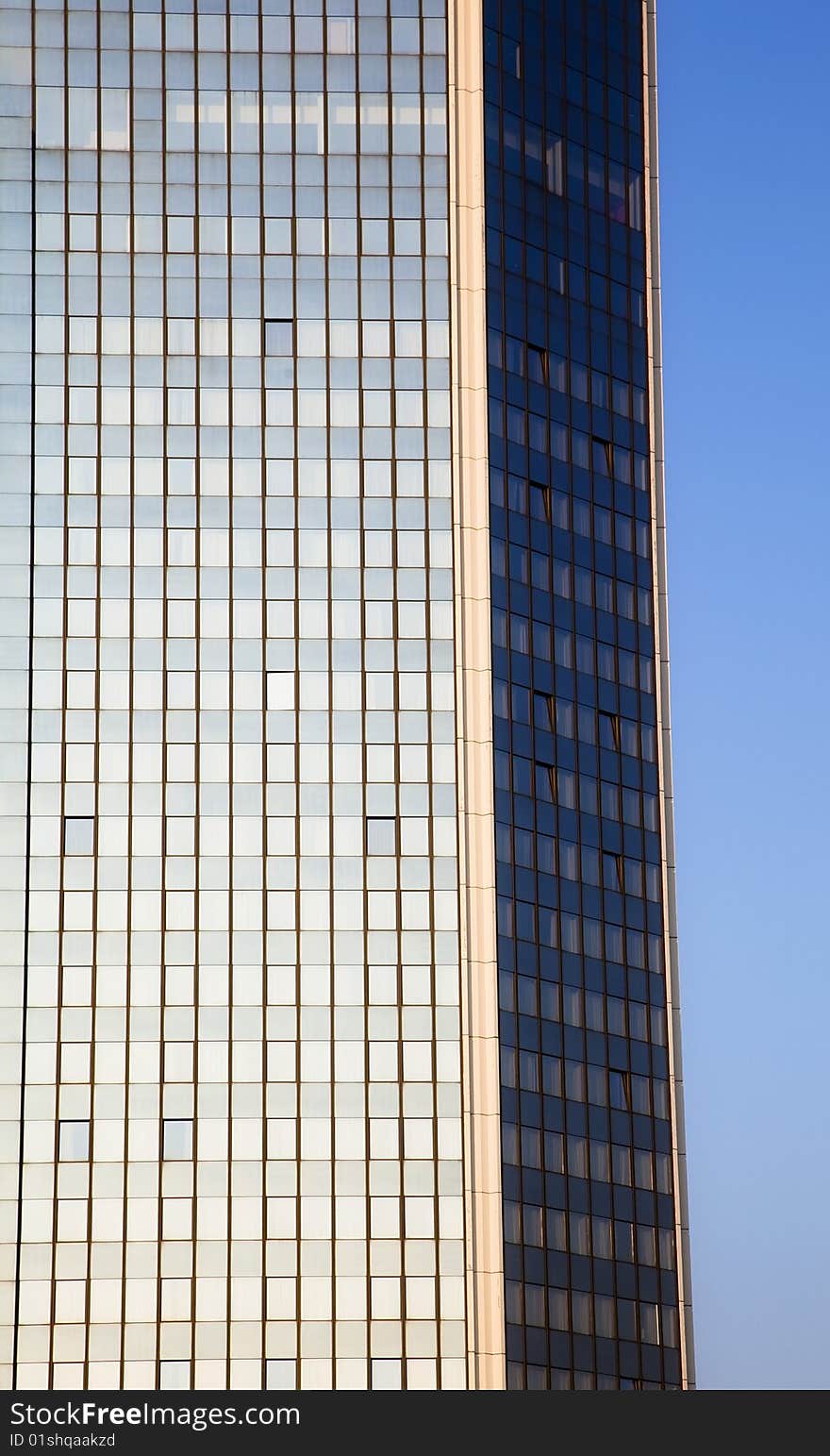 Blue skyscraper facade over clear sky.