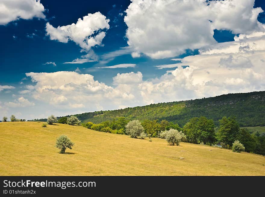 Rural landscape with blue sky and clouds on it