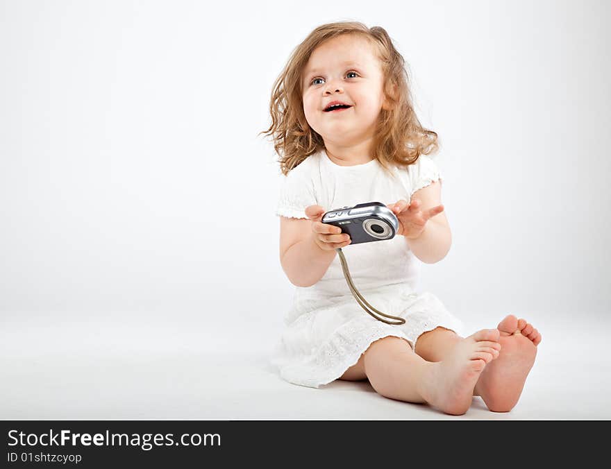 Little girl with camera on gray background