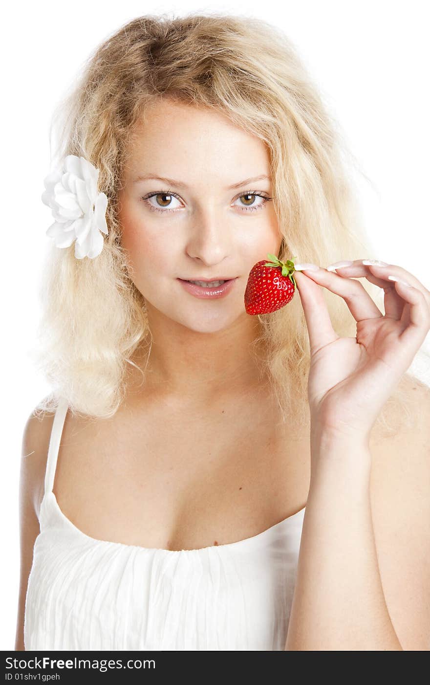 Young woman in white dress eating strawberries