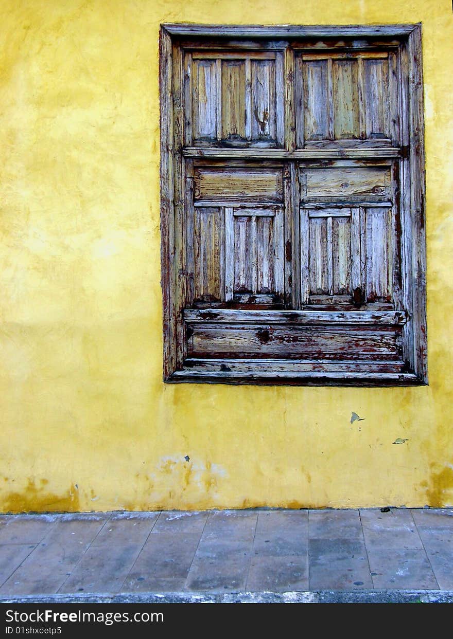 Old wooden window in the yellow wall. Old wooden window in the yellow wall