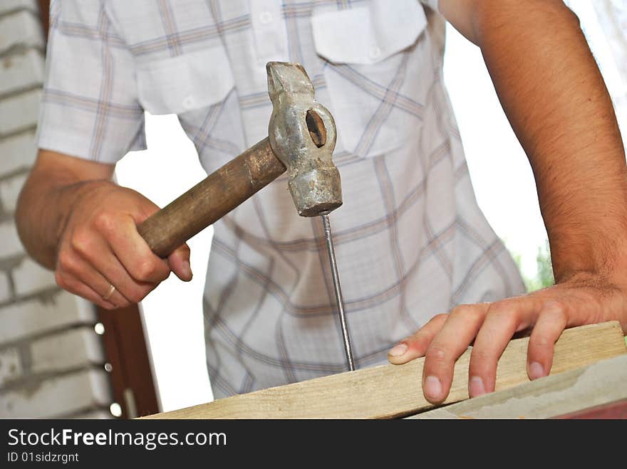 Hammer pounding nail close-up