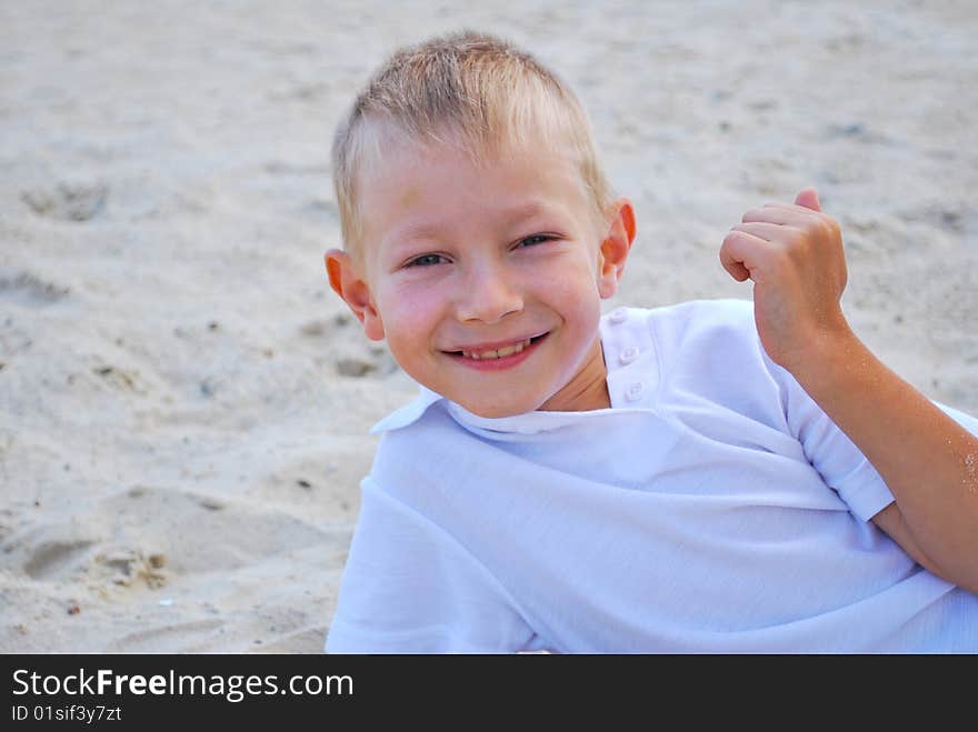 Happy boy on sand background