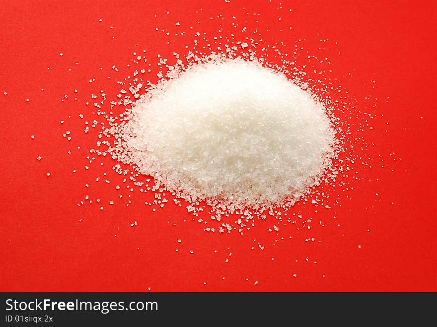 Sugar grains over red background.