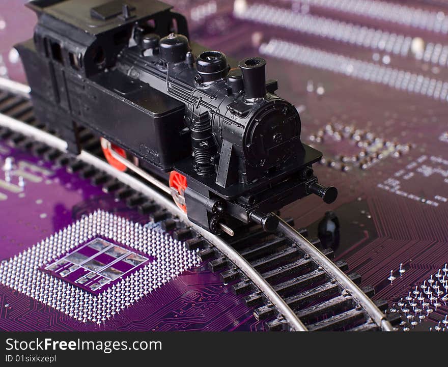 Digital transportation concept: toy locomotive on computer motherboard