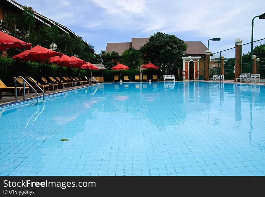 Sunbeds and umbrellas near resort's pool. Sunbeds and umbrellas near resort's pool