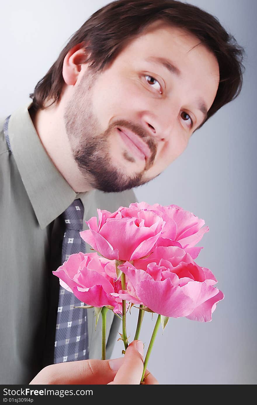Cute man offering pink roses and smiling
