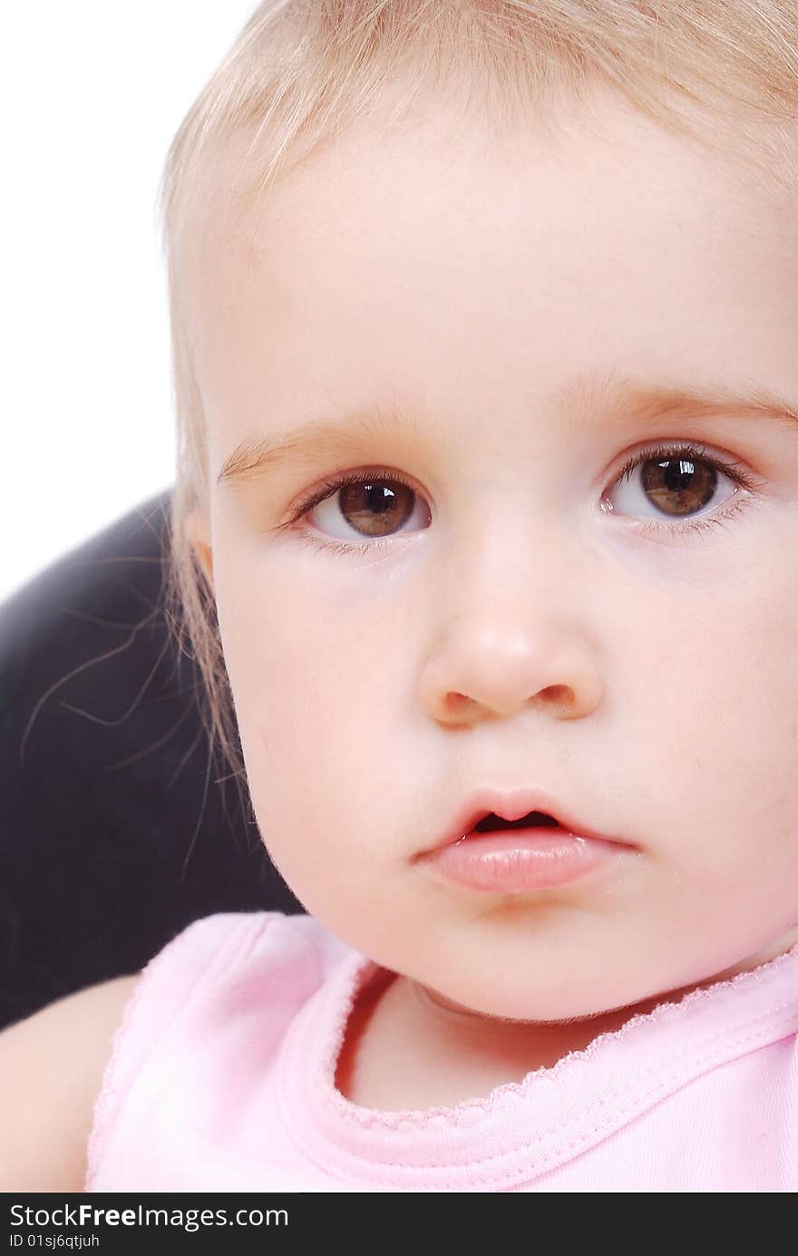 Baby sitting on the black chair isolated in white