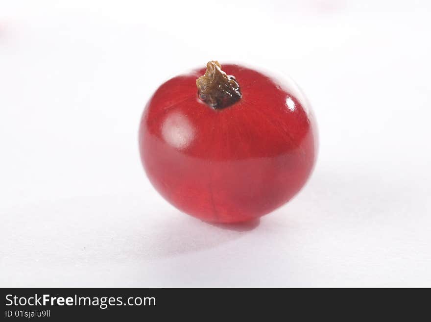 Extreme close up of a red currant on a white background isolated.