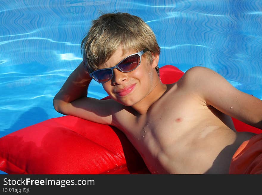 Boy With Sun Glasses Relaxing On Airbed